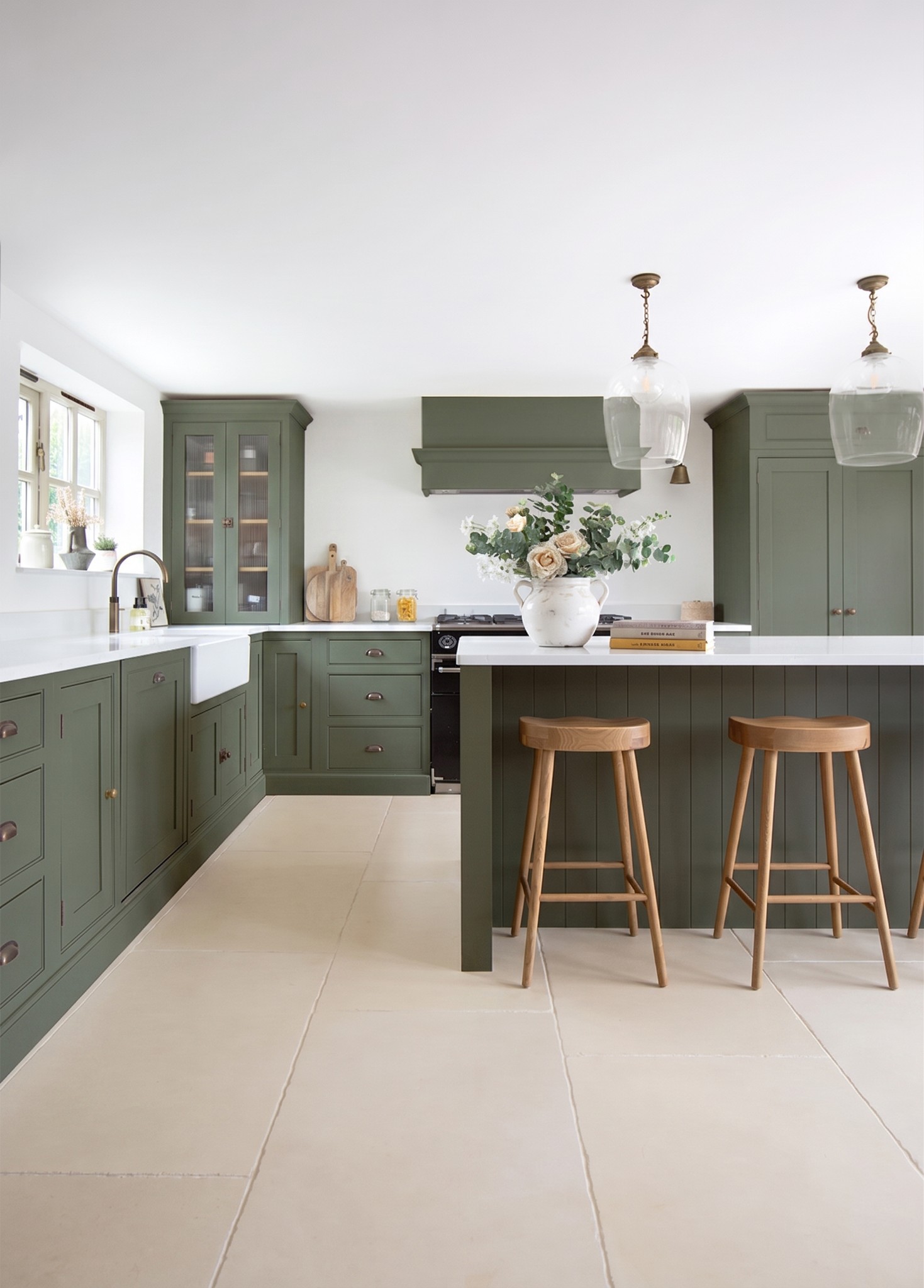 Green shaker kitchen with an island and timber bar stools