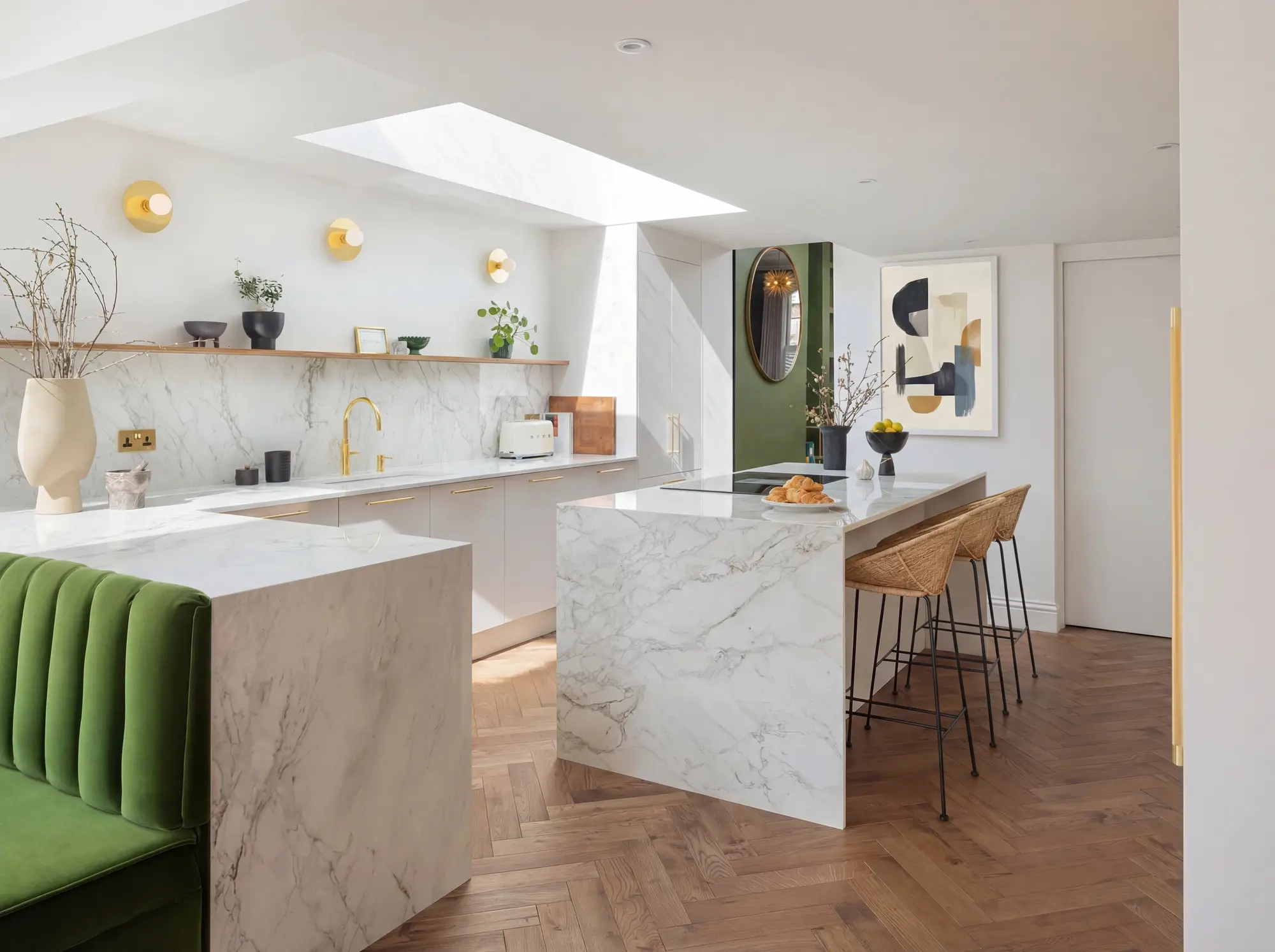 Kitchen with a marble waterfall island, green banquette seating and herringbone floor