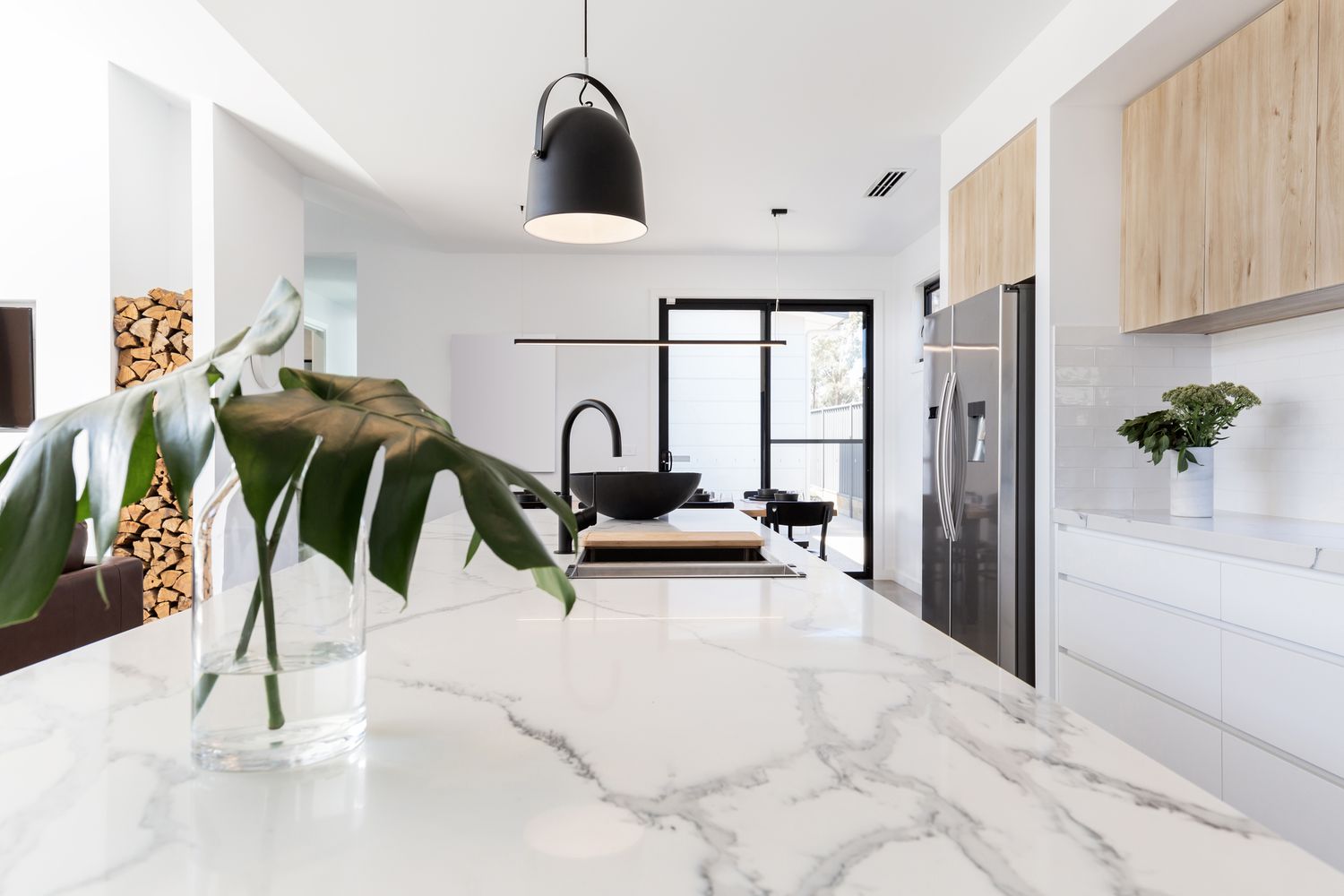 White marble-effect worktop in a modern kitchen with a black pendant light